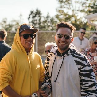 Two men in onesies and sunglasses